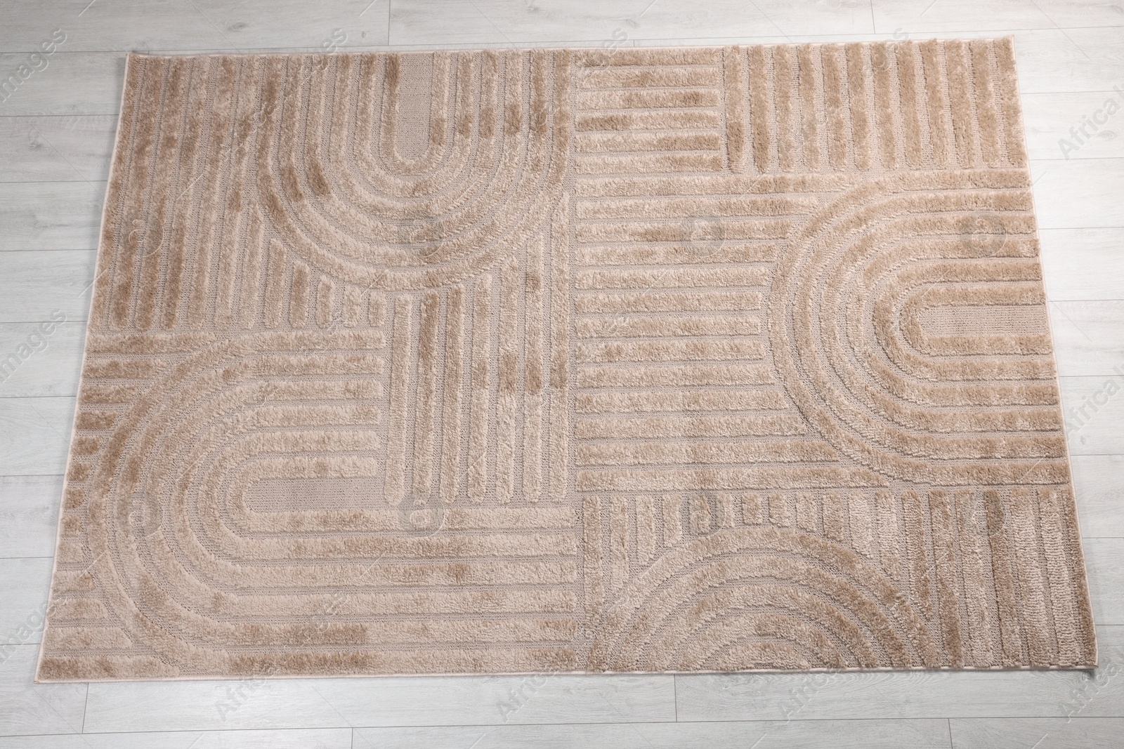Stylish rug with pattern on light wooden floor, top view Photo of Stylish rug with pattern on light wooden floor, top view