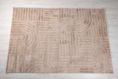 Photo of Stylish rug with pattern on light wooden floor, top view