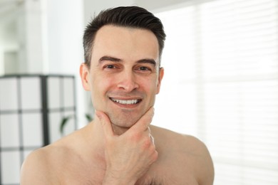 Photo of Smiling man after shaving at home, closeup
