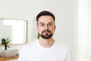 Photo of Portrait of handsome man before shaving in bathroom