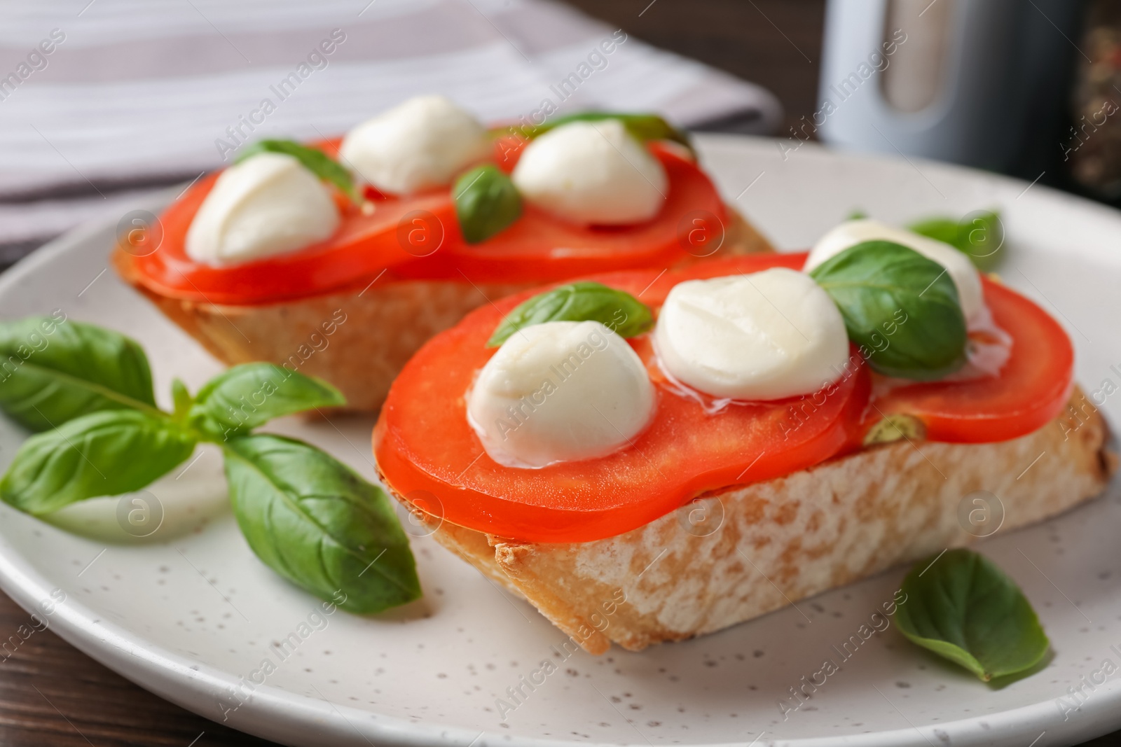 Photo of Tasty sandwiches with mozzarella cheese, tomatoes and basil on table, closeup