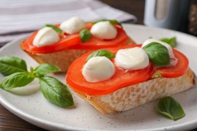 Photo of Tasty sandwiches with mozzarella cheese, tomatoes and basil on table, closeup
