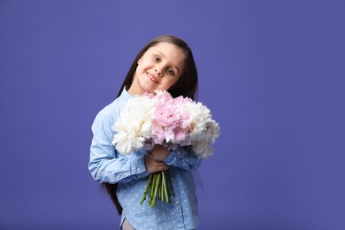 Photo of Cute little girl with bouquet of beautiful peonies on purple background