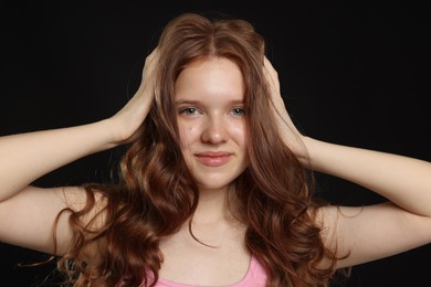 Photo of Portrait of beautiful teenage girl with healthy wavy hair on black background