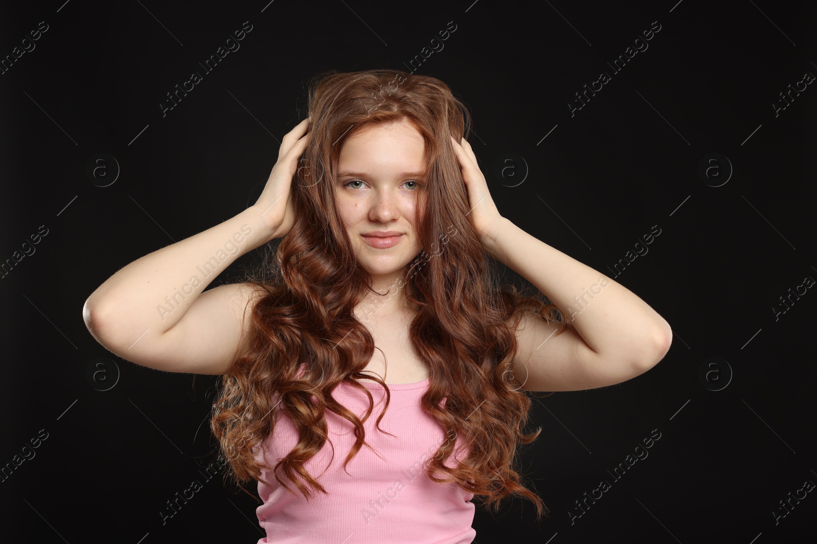 Portrait of beautiful teenage girl with healthy wavy hair on black background Photo of Portrait of beautiful teenage girl with healthy wavy hair on black background
