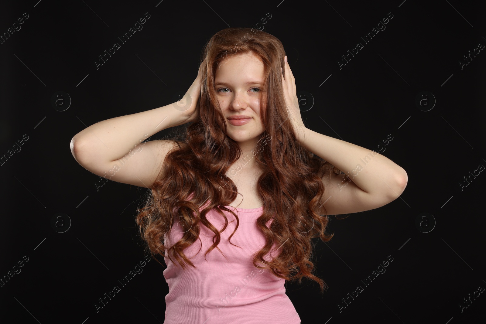 Portrait of beautiful teenage girl with healthy wavy hair on black background Photo of Portrait of beautiful teenage girl with healthy wavy hair on black background
