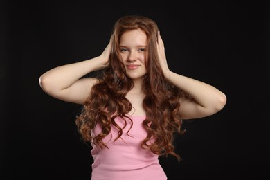 Photo of Portrait of beautiful teenage girl with healthy wavy hair on black background