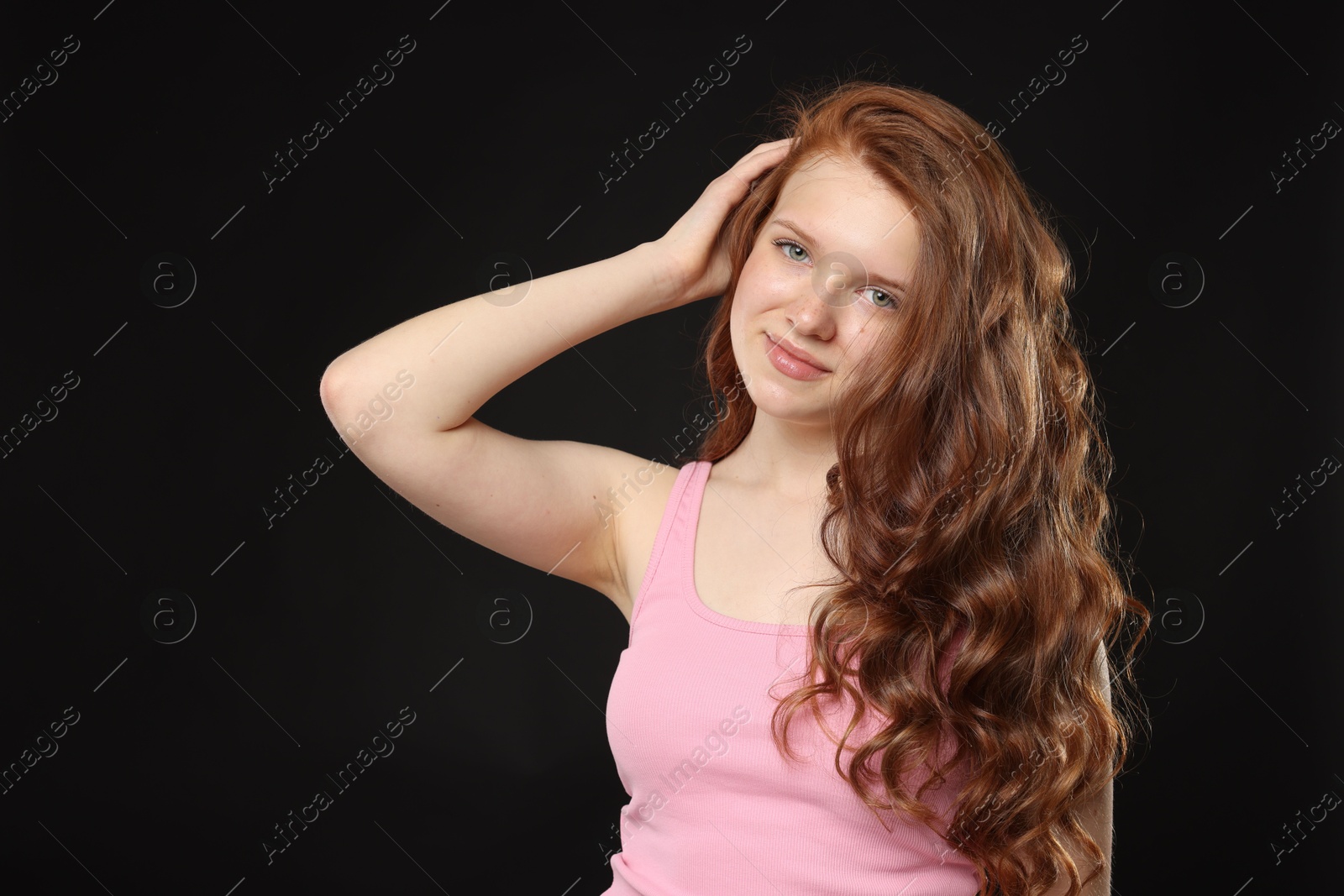Portrait of beautiful teenage girl with healthy wavy hair on black background Photo of Portrait of beautiful teenage girl with healthy wavy hair on black background