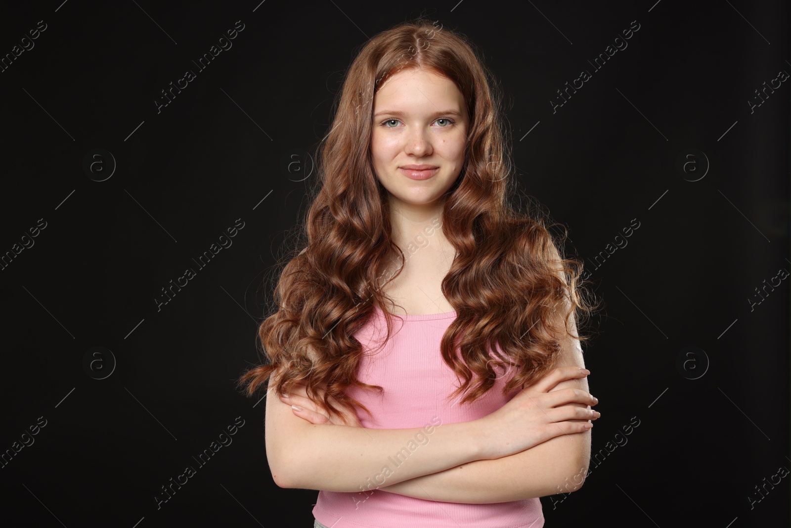 Portrait of beautiful teenage girl with healthy wavy hair on black background Photo of Portrait of beautiful teenage girl with healthy wavy hair on black background