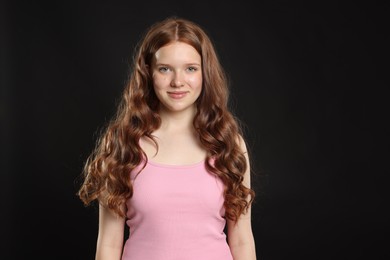 Photo of Portrait of beautiful teenage girl with healthy wavy hair on black background