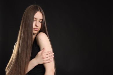 Photo of Beautiful teenage girl with healthy long hair on black background. Space for text