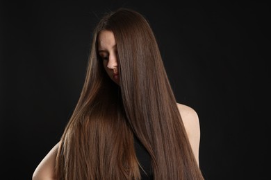 Photo of Beautiful teenage girl with healthy long hair on black background