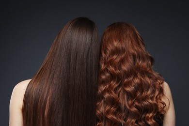 Photo of Teenage girls with healthy long hair on dark grey background, back view