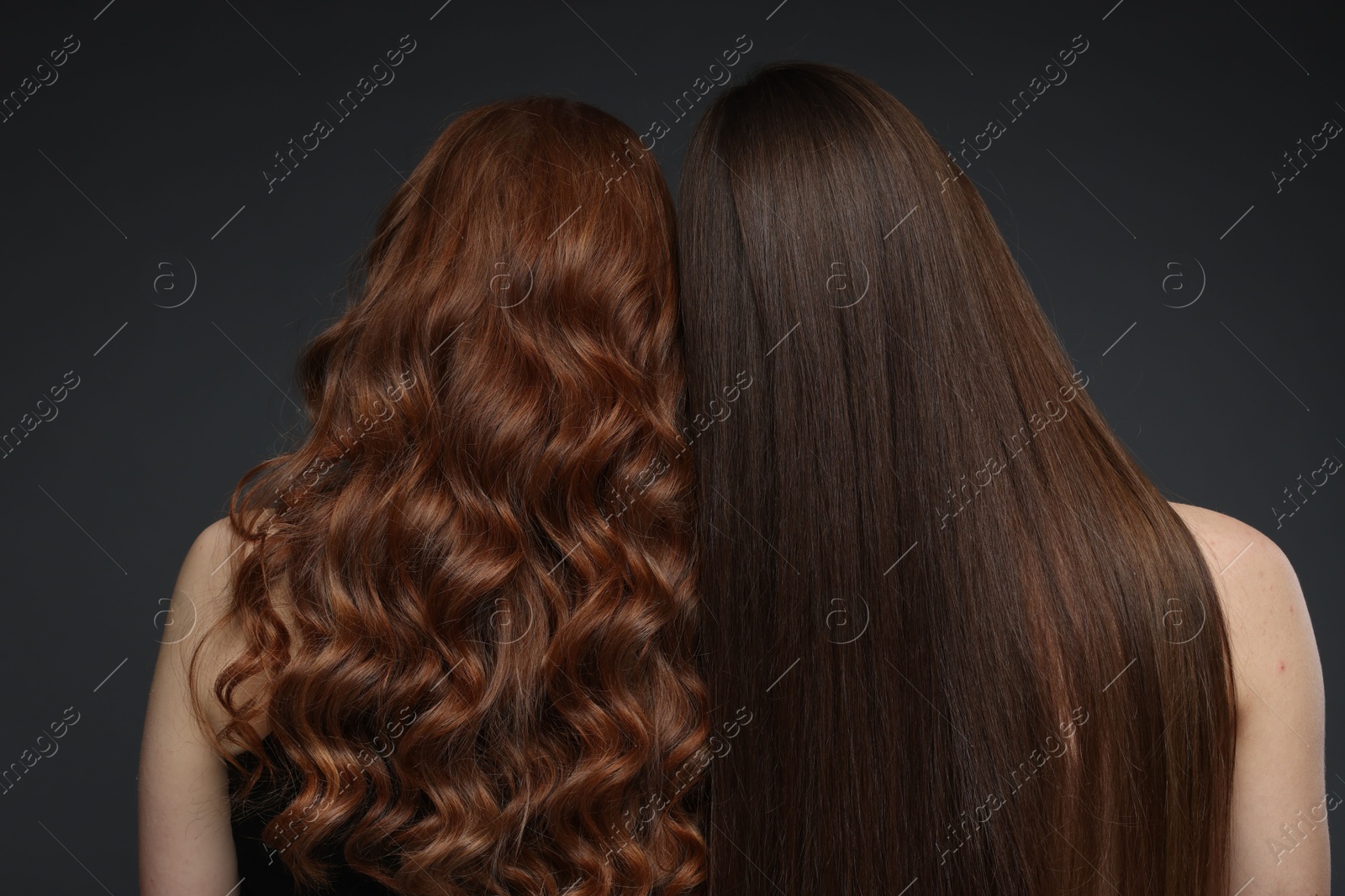 Teenage girls with healthy long hair on dark grey background, back view Photo of Teenage girls with healthy long hair on dark grey background, back view