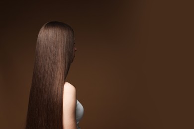 Photo of Teenage girl with healthy long hair on brown background. Space for text