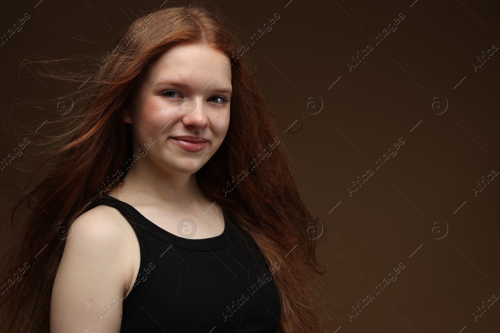 Portrait of beautiful teenage girl with healthy wavy hair on brown background. Space for text Photo of Portrait of beautiful teenage girl with healthy wavy hair on brown background. Space for text
