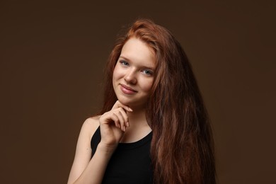Photo of Portrait of beautiful teenage girl with healthy wavy hair on brown background