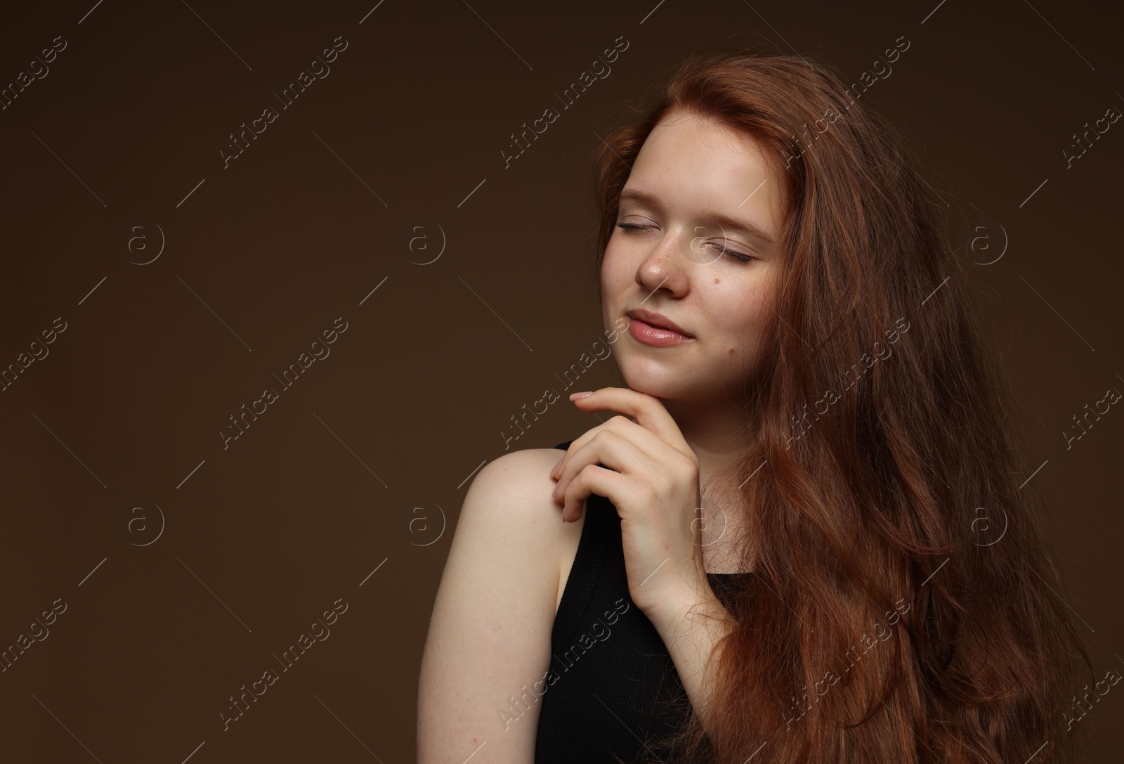 Beautiful teenage girl with healthy wavy hair on brown background. Space for text Photo of Beautiful teenage girl with healthy wavy hair on brown background. Space for text