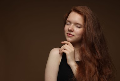 Photo of Beautiful teenage girl with healthy wavy hair on brown background. Space for text