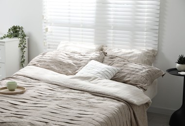 Photo of Comfortable bed with beautiful linens in bedroom