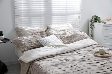 Photo of Comfortable bed with beautiful linens in bedroom