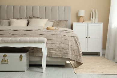 Photo of Comfortable bed with beautiful linens in bedroom