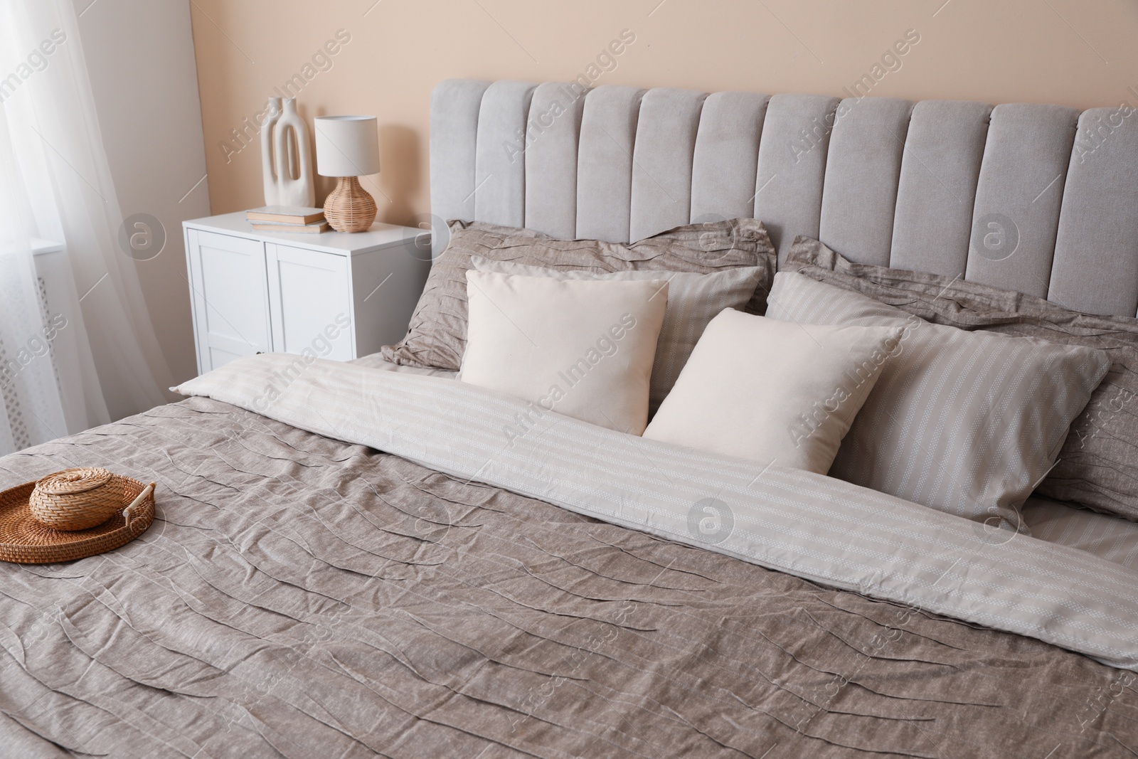 Photo of Comfortable bed with beautiful linens in bedroom