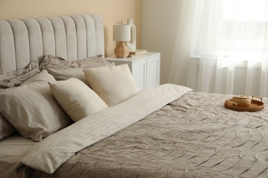 Photo of Comfortable bed with beautiful linens in bedroom