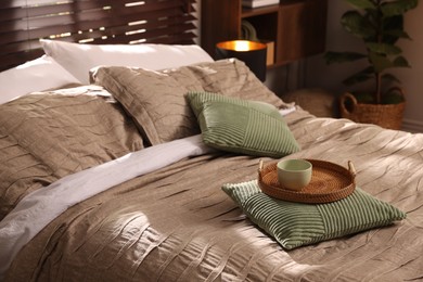Photo of Comfortable bed with beautiful linens and decor in bedroom