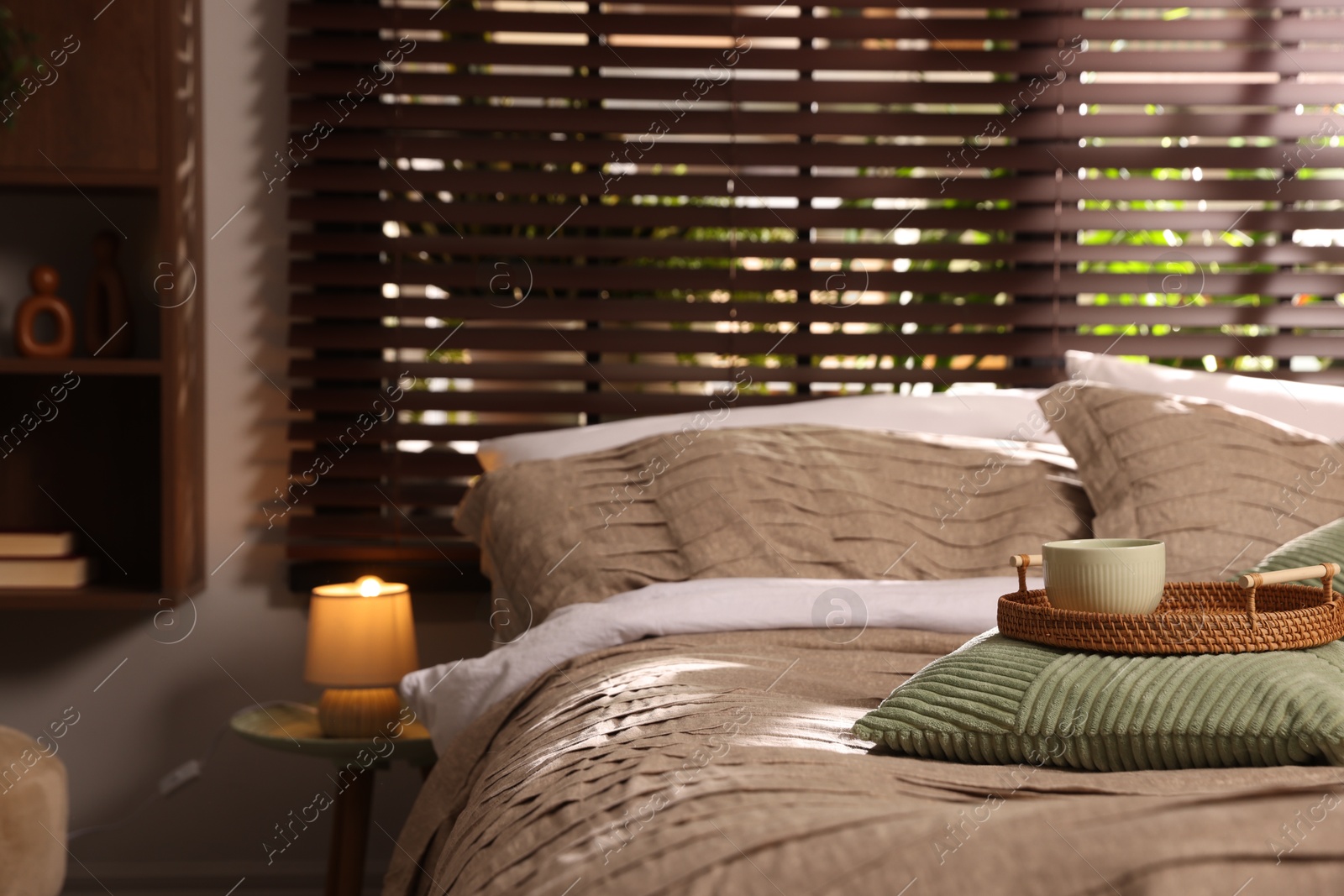 Comfortable bed with beautiful linens and decor in bedroom Photo of Comfortable bed with beautiful linens and decor in bedroom