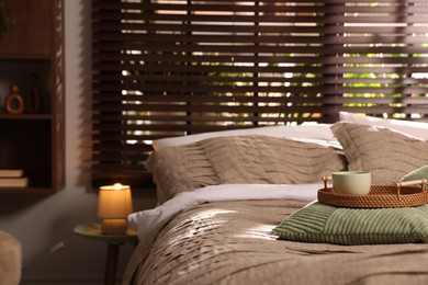 Photo of Comfortable bed with beautiful linens and decor in bedroom