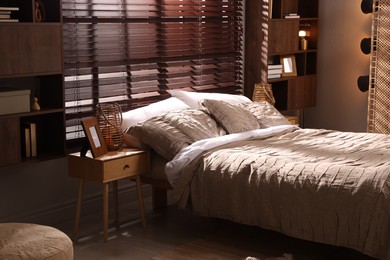 Photo of Comfortable bed with beautiful linens in bedroom