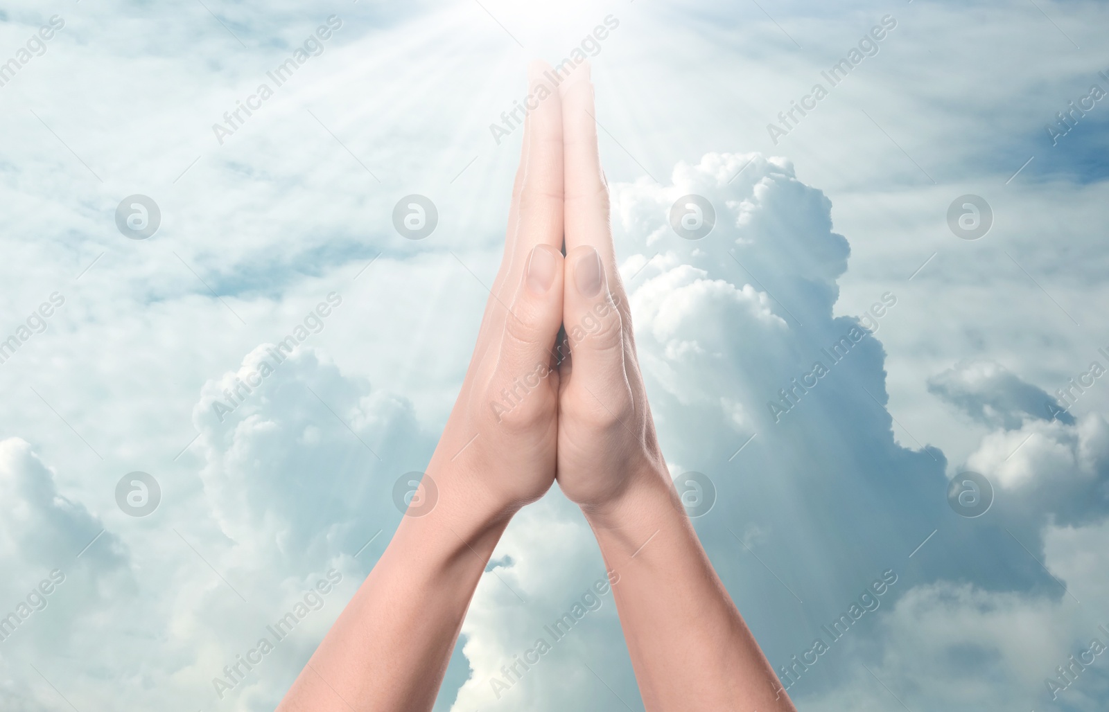 Image of Woman praying against beautiful sky with sun, closeup
