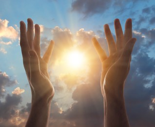 Image of Man praying against beautiful sky with sun, closeup