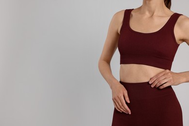 Photo of Woman with flat belly on gray background closeup. Space for text