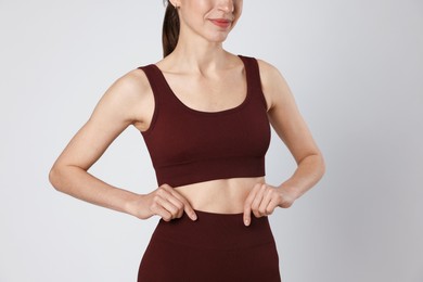 Photo of Woman with flat belly on gray background closeup
