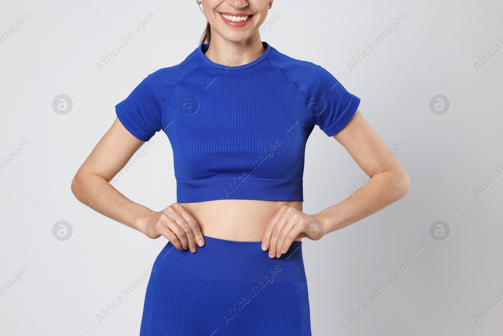 Woman with flat belly on gray background closeup Photo of Woman with flat belly on gray background closeup