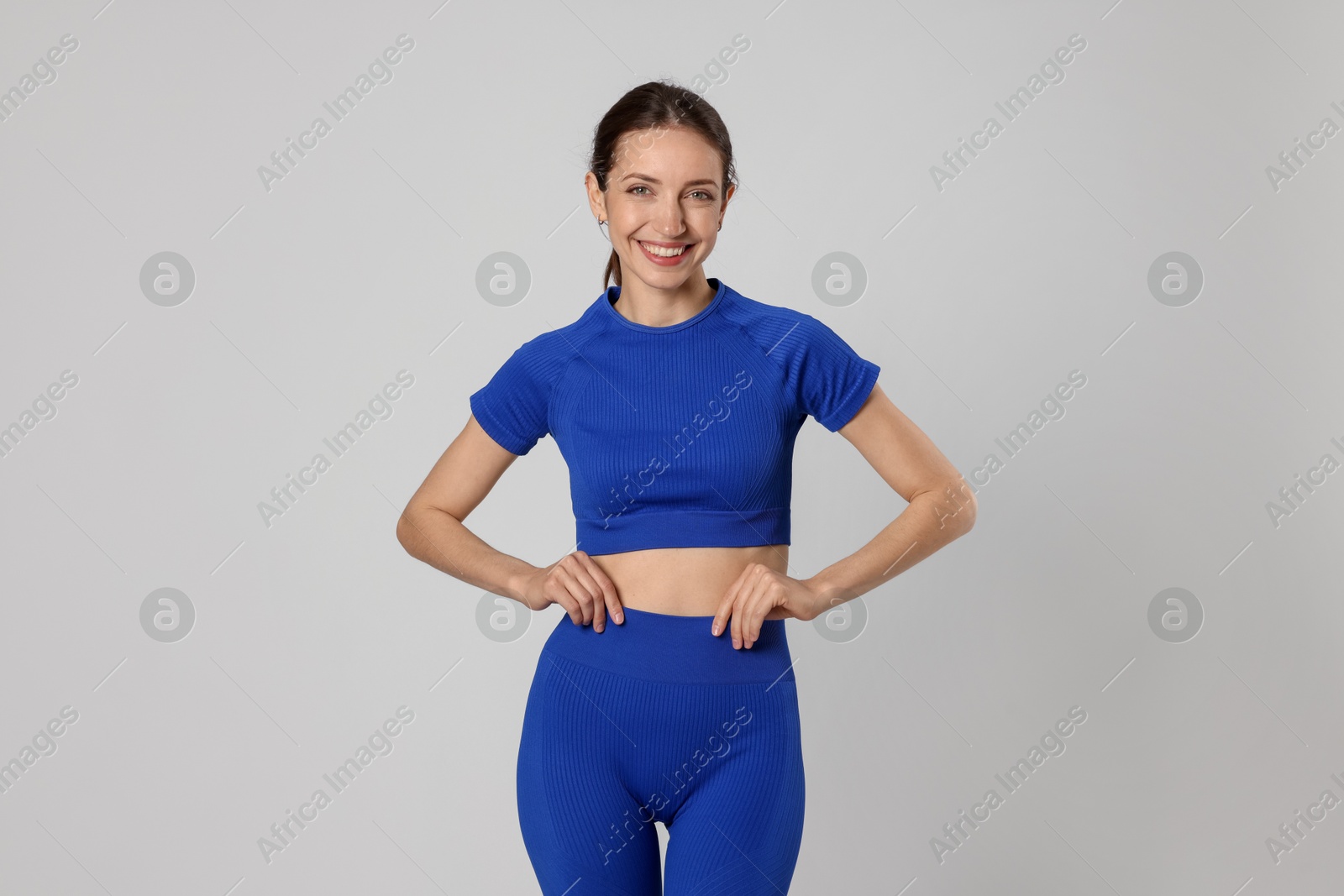 Beautiful woman with flat belly on gray background Photo of Beautiful woman with flat belly on gray background