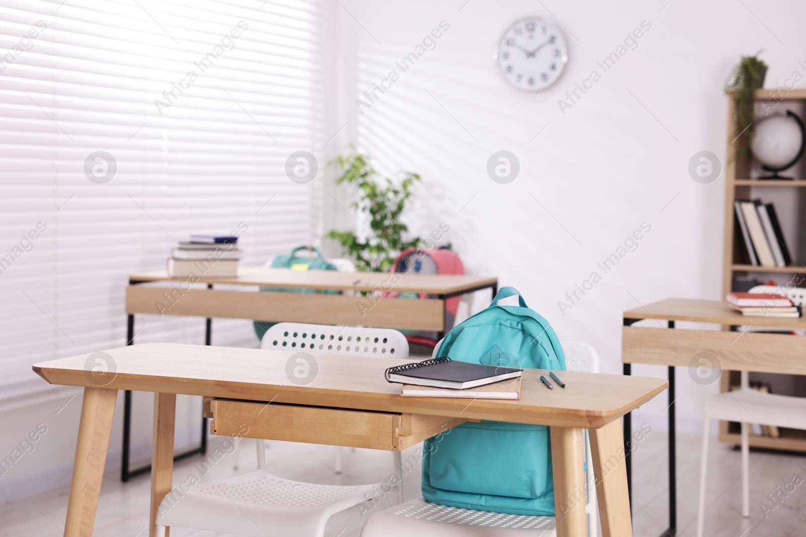 Empty classroom with wooden desks, chairs and backpacks Photo of Empty classroom with wooden desks, chairs and backpacks