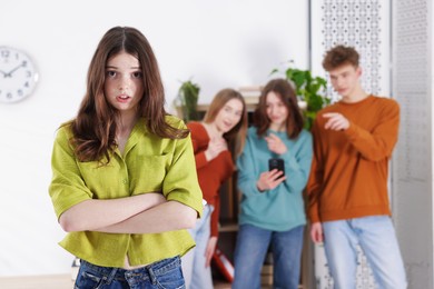 Photo of Teenage girl suffering from bullying at school, selective focus