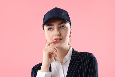 Photo of Beautiful woman in stylish baseball hat on pink background