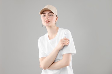 Photo of Beautiful woman in stylish baseball hat on grey background