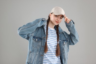 Photo of Beautiful woman in stylish baseball hat on grey background
