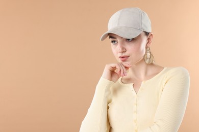 Photo of Beautiful woman in stylish baseball hat on beige background. Space for text