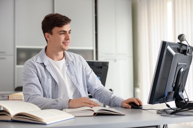 Photo of Man working on computer at desk in public library