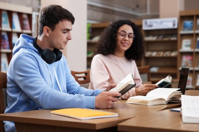 Photo of People studying together at desks in public library