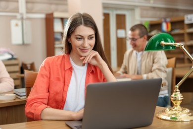 Photo of People studying at desks in public library, selective focus