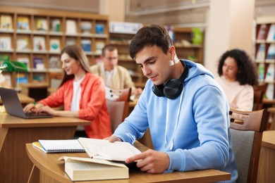 Photo of People studying at desks in public library, selective focus