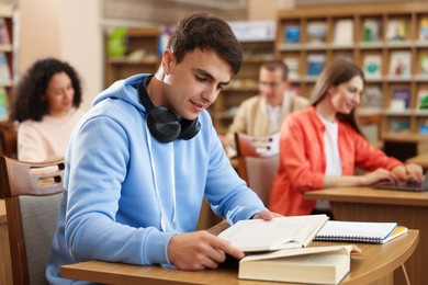 Photo of People studying at desks in public library, selective focus