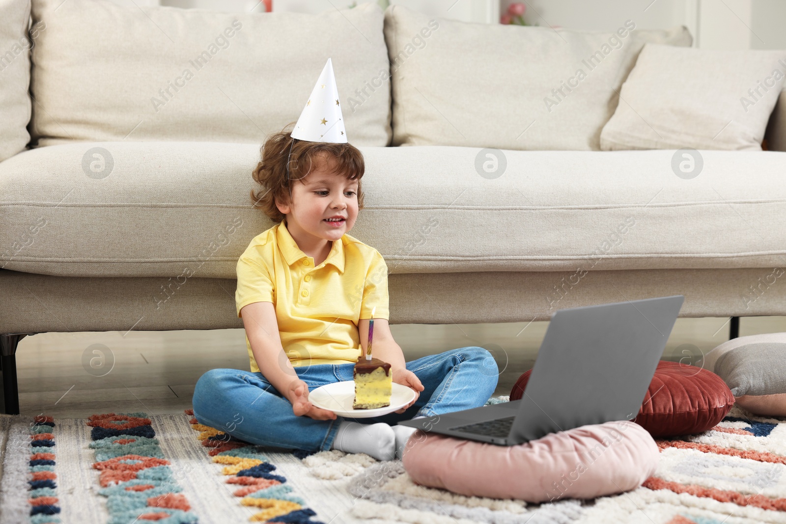 Birthday celebration. Little boy with piece of cake having video call via laptop at home Photo of Birthday celebration. Little boy with piece of cake having video call via laptop at home